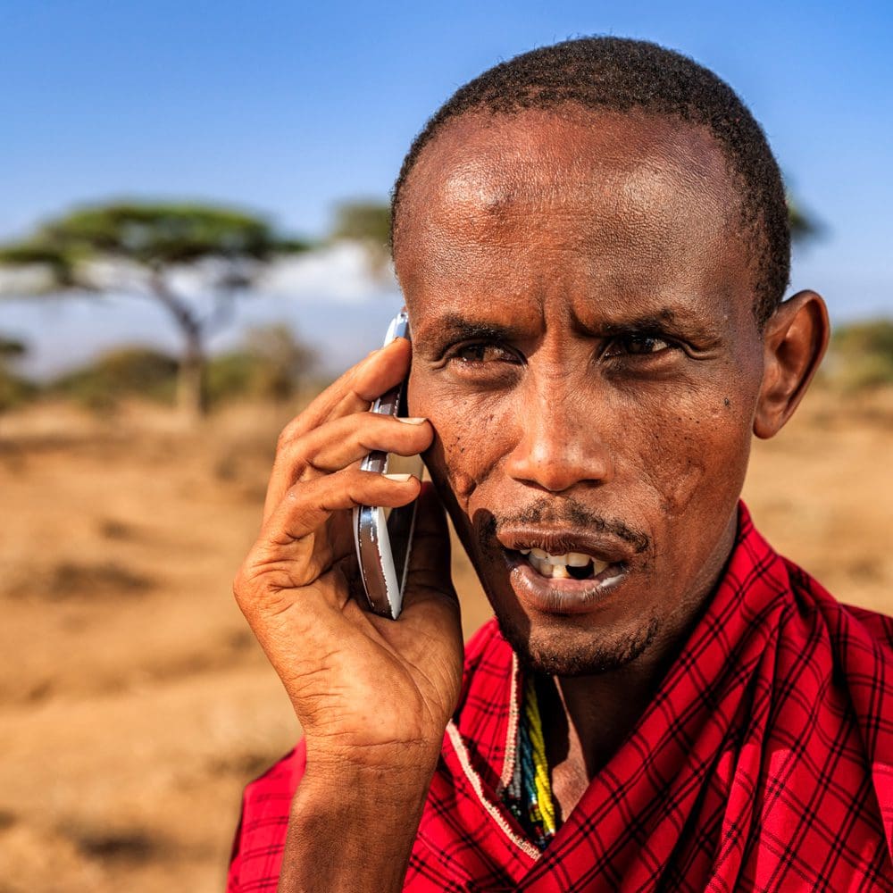 Warrior from Maasai tribe using mobile phone, Kenya, Africa